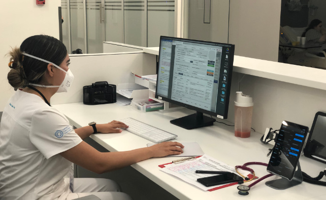 nurse reading digital report in nursing station